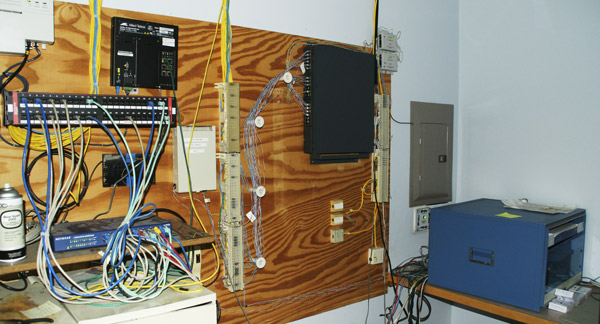 Photo of a disorganized and deteriorating communications hub.